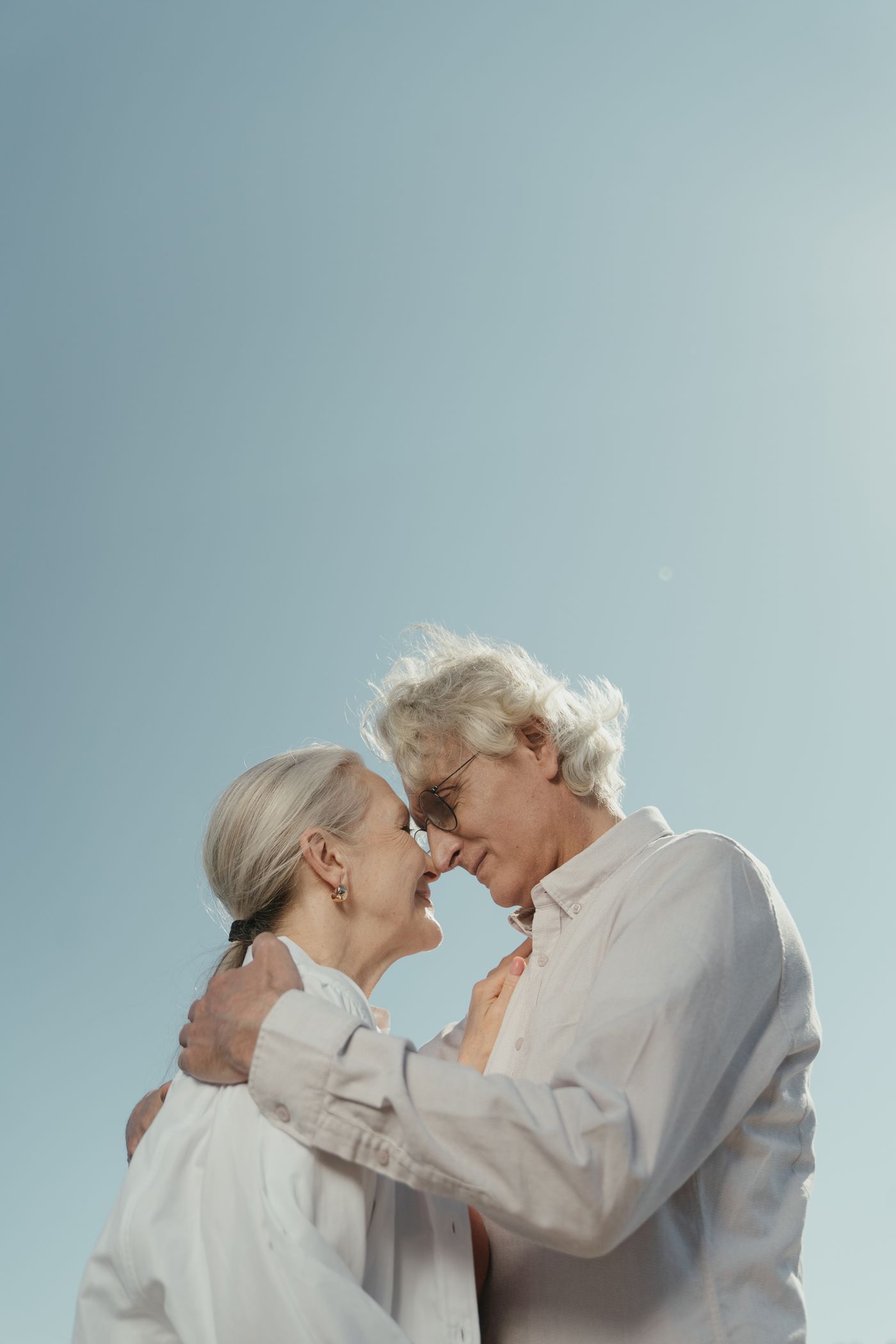 An older couple embracing, smiling with eyes closed